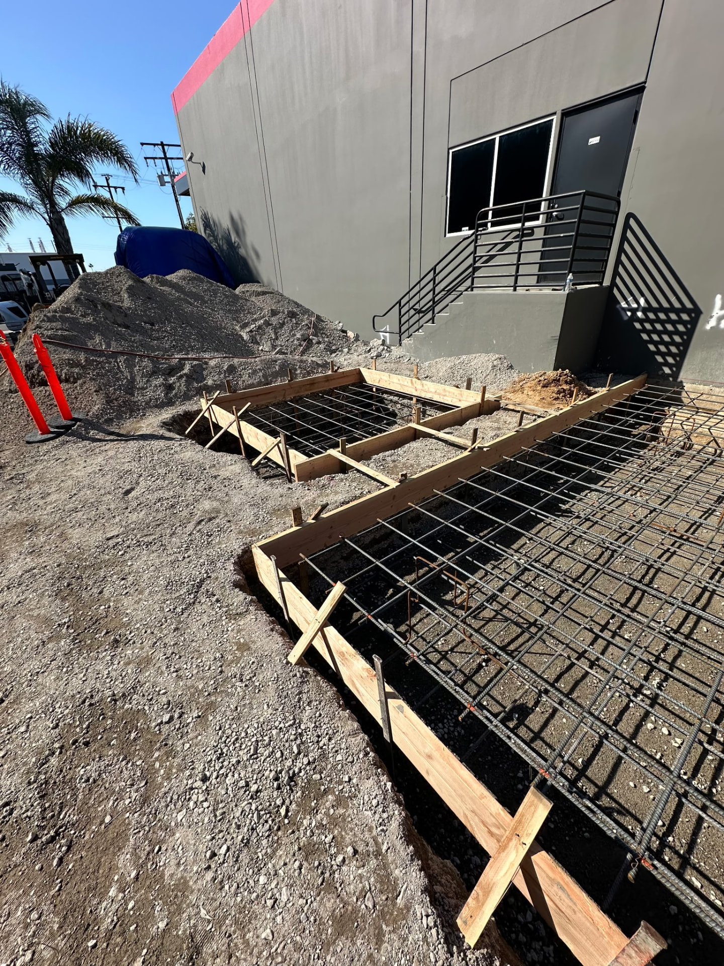 Formwork and rebar mat set for a concrete equipment foundation beside a commercial building